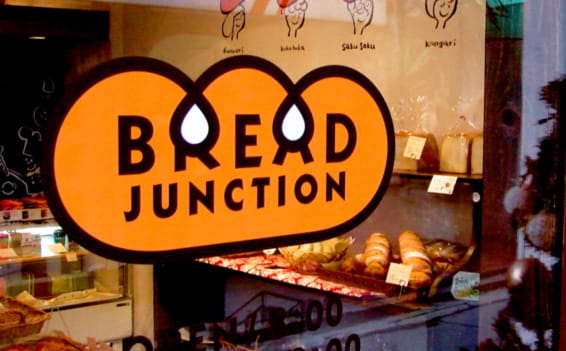 パン屋さんの窓に貼られたロゴのシールの写真