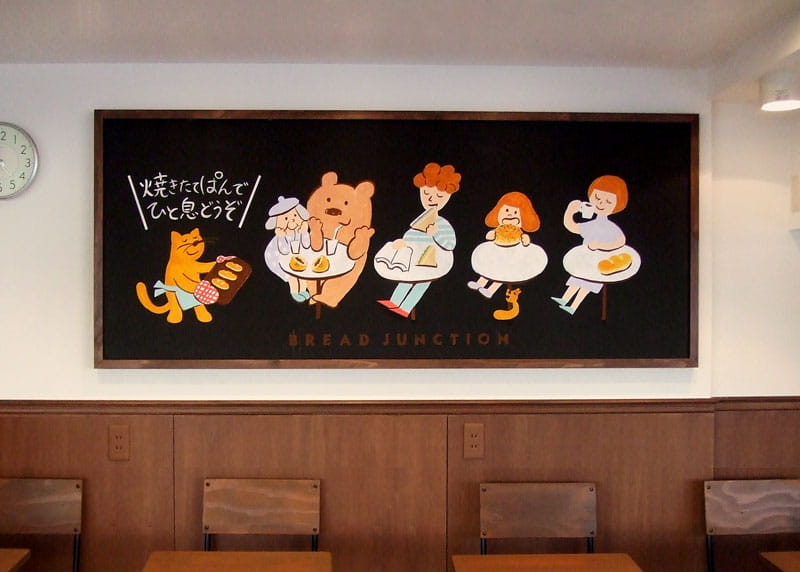BREAD JUNCTIONに設置されている黒板へのペイント写真：老若男女や動物たちがパンを食べている様子